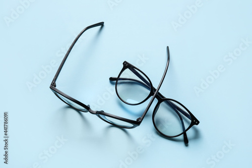 Different stylish eyeglasses on color background