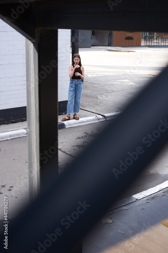 urban landscape a young girl stands on the asphalt in jeans and a T-shirt