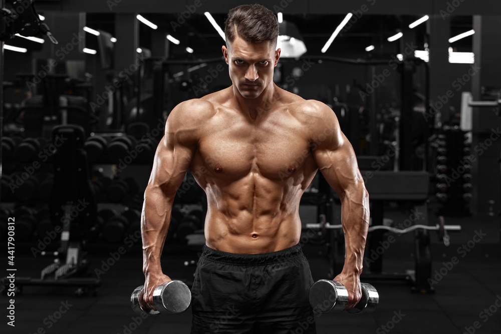 Muscular man working out in gym, strong male naked torso abs Muscular man working out in gym, strong male naked torso abs