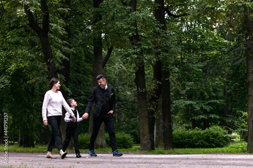 A family of three walking in the park