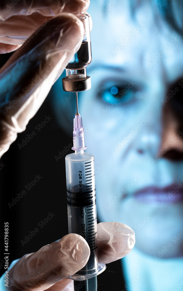 hands filling a syringe from vaccine bottle hands filling a syringe from vaccine bottle