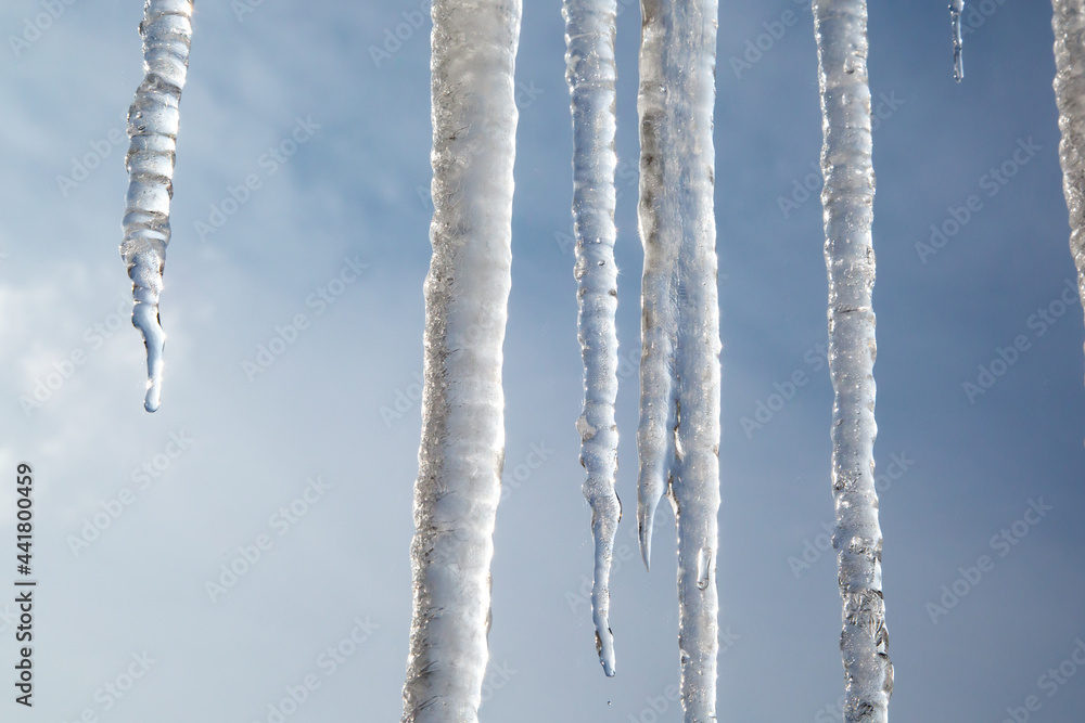 Icicles III - Group of icicles with a wintery blue cloudy sky backdrop Icicles III - Group of icicles with a wintery blue cloudy sky backdrop