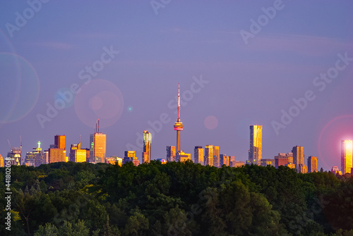 Toronto skyline on a purple sky background with lens flare at sunset
