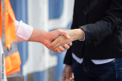 Close Up on Asian Worker Having a Hand Shake with His Female Manager at Container Cargo Site