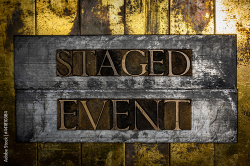 Staged Event text formed with real authentic typeset letters on vintage textured silver grunge copper and gold background