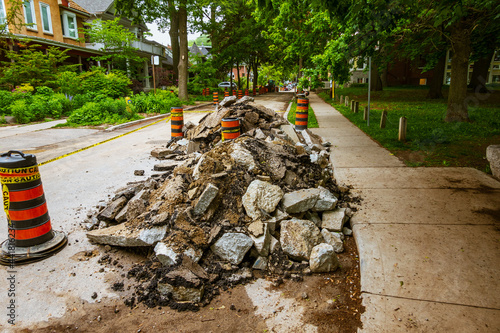 Photography Torn up and piled asphalt paving on a residential street part  of water system repair project in a Toronto neighbourhood in summer