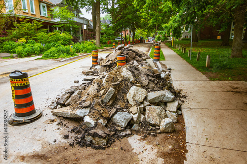 Photography Torn up and piled asphalt paving on a residential street part  of water system repair project in a Toronto neighbourhood in summer