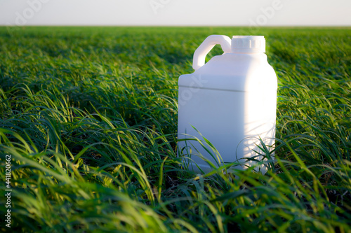 White canister against the background of agriculture, canisters from under different types of chemical products.