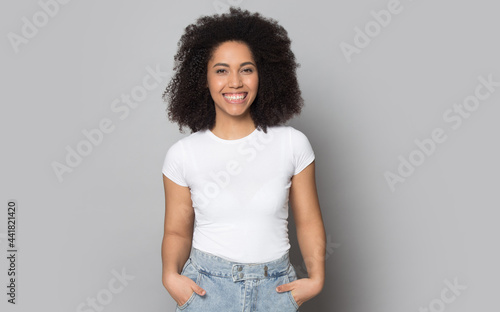 Portrait of smiling African American young woman in casual clothes isolated on grey studio background. Happy millennial mixed race female actress modern feel excited overjoyed. Diversity concept.