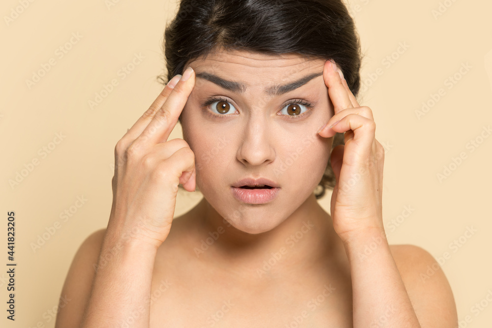 Portrait of anxious young Indian woman touch face worry about wrinkles think of Botox treatment. Unhappy mixed race female frustrated with skin, need anitiage procedure. Skincare concept. Portrait of anxious young Indian woman touch face worry about wrinkles think of Botox treatment. Unhappy mixed race female frustrated with skin, need anitiage procedure. Skincare concept.
