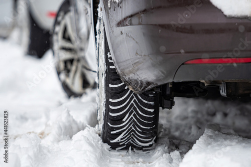 car tires on winter road covered with snow, close-up