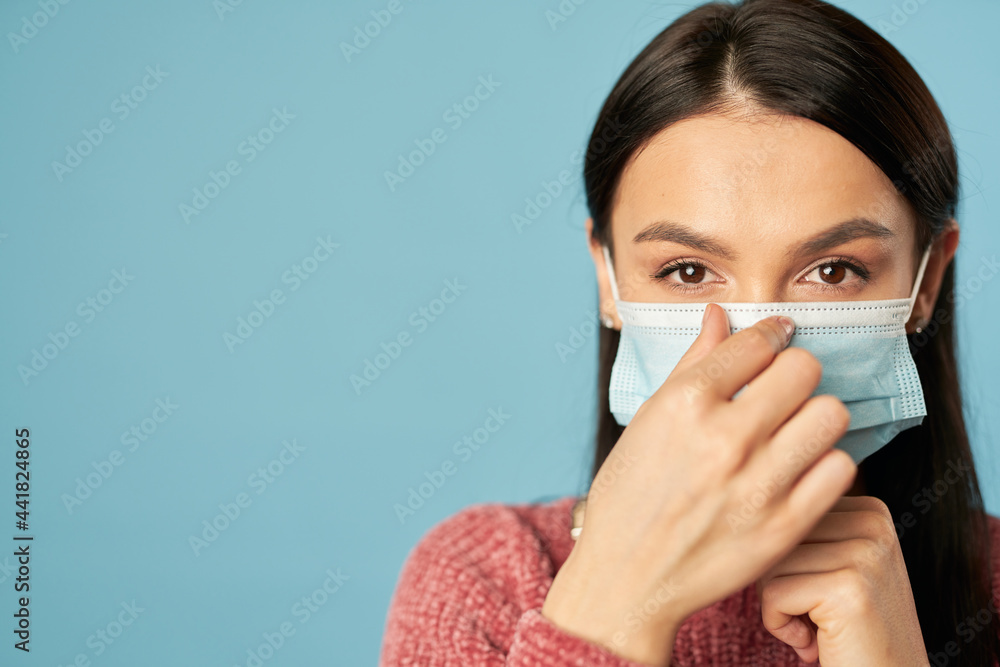 Young woman posing and correcting anti virus face mask Young woman posing and correcting anti virus face mask