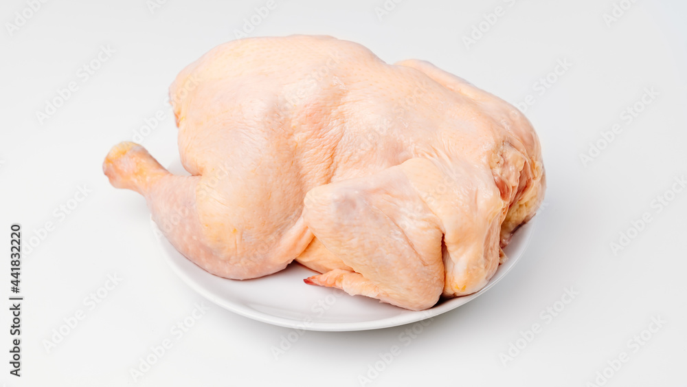 carcass of raw chicken on a white plate on a white background. carcass of raw chicken on a white plate on a white background.