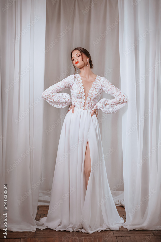 Beautiful brunette bride with light make-up in white dress in an exquisite interior Beautiful brunette bride with light make-up in white dress in an exquisite interior