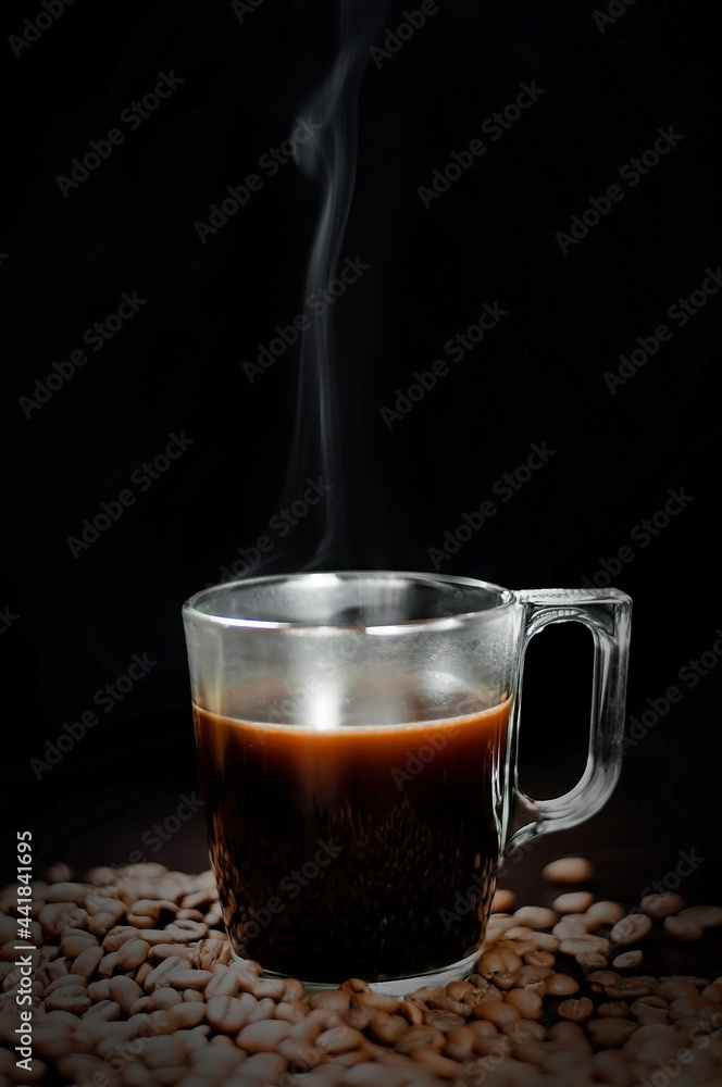 a cup of coffee on a black background with grains. Selective focus a cup of coffee on a black background with grains. Selective focus