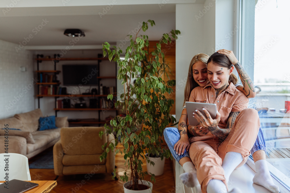 Female couple spending weekend at home and using technology Female couple spending weekend at home and using technology