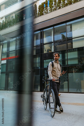 Man using phone while out in the city with bike