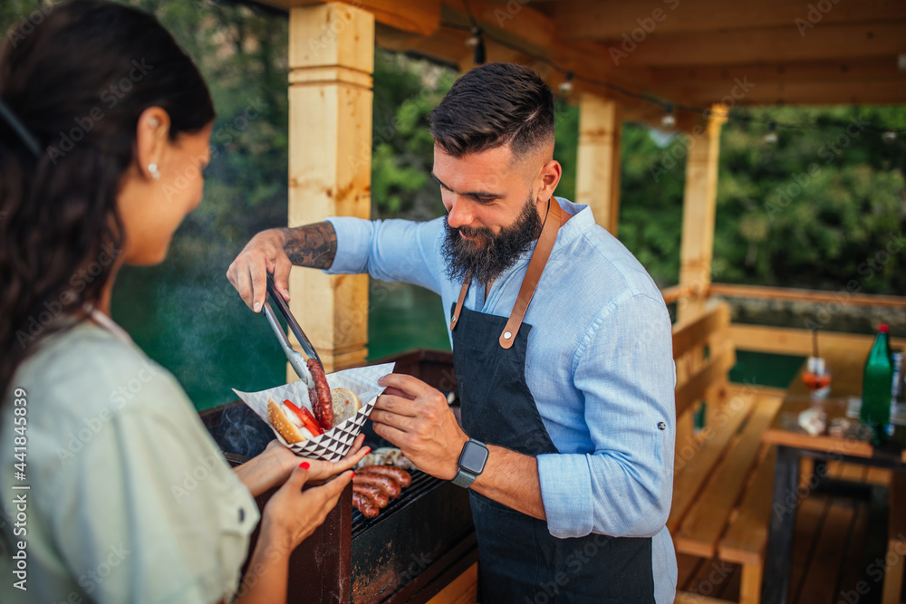 Obraz premium Lovely couple making burgers outdoors