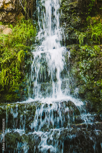 Motion blur. Waterfall in  mountains. Water splashes. Long exposure  selective focus.