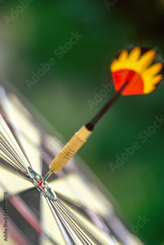 Dart arrow in target center of dartboard photo