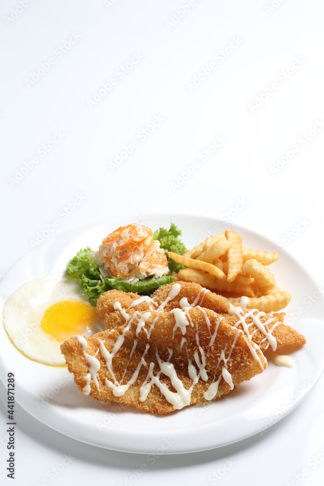 deep fried golden crispy fish fillet and chips with fried egg, French fries, coleslaw salad in tartar sauce western cuisine menu deep fried golden crispy fish fillet and chips with fried egg, French fries, coleslaw salad in tartar sauce western cuisine menu