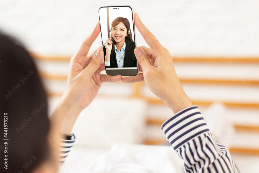 young manlying on the bed at home and  having  video call with  business woman