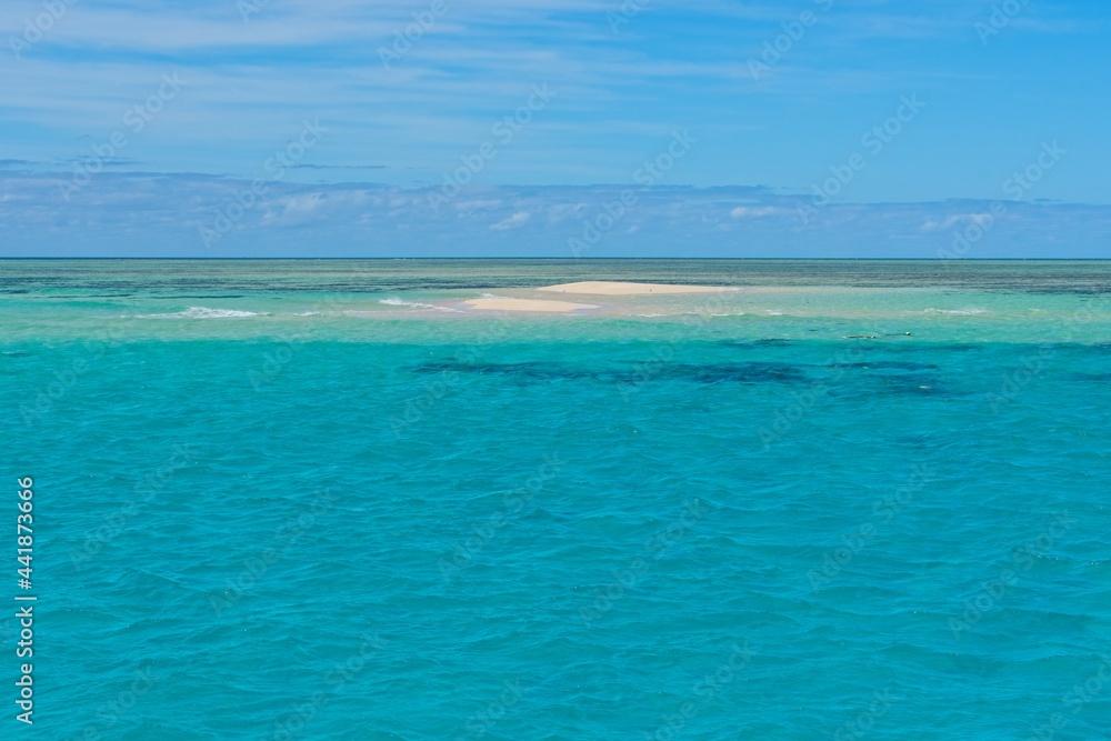 Sand cay in the Great Barrier Reef surrounded by crystal clear water
