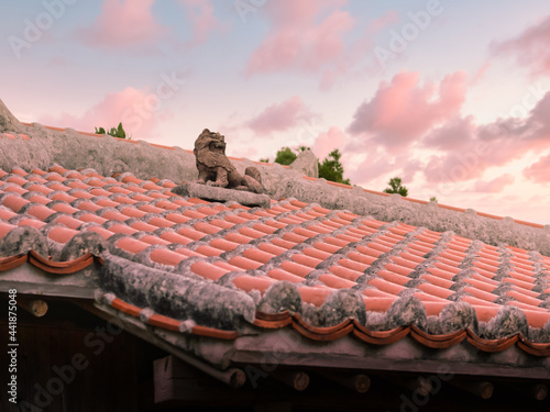 夕暮れ時、沖縄の伝統的な屋根の赤瓦とシーサー