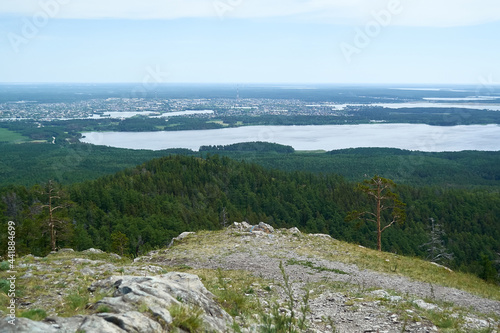 Views of the city of Kyshtym and Lake Sugomak in the Chelyabinsk region. One of the peaks of the Ural mountains is Sugomak. Trekking and weekend hikes in the low mountains. Cloudy day.