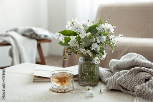 Canvas Print Cozy home composition with a cup of tea, a book and flowers.