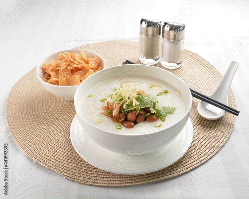 chef boiled Hong Kong teochew congee porridge with peanut, onion and cracker healthy halal vegan menu photo