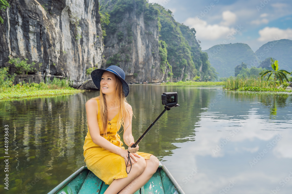 Woman tourist in boat on the lake Tam Coc, Ninh Binh, Viet nam. It's is UNESCO World Heritage Site, renowned for its boat cave tours. It's Halong Bay on land of Vietnam. Vietnam reopens borders after