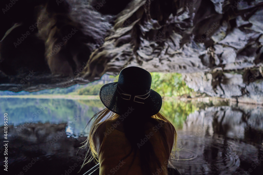 Woman tourist in boat on the lake Tam Coc, Ninh Binh, Viet nam. It's is UNESCO World Heritage Site, renowned for its boat cave tours. It's Halong Bay on land of Vietnam. Vietnam reopens borders after Woman tourist in boat on the lake Tam Coc, Ninh Binh, Viet nam. It's is UNESCO World Heritage Site, renowned for its boat cave tours. It's Halong Bay on land of Vietnam. Vietnam reopens borders after