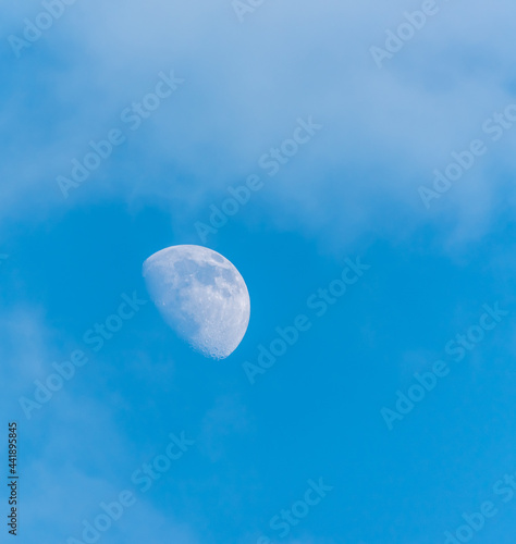 Half Moon in a Blue and Cloudy Sky in Daytime