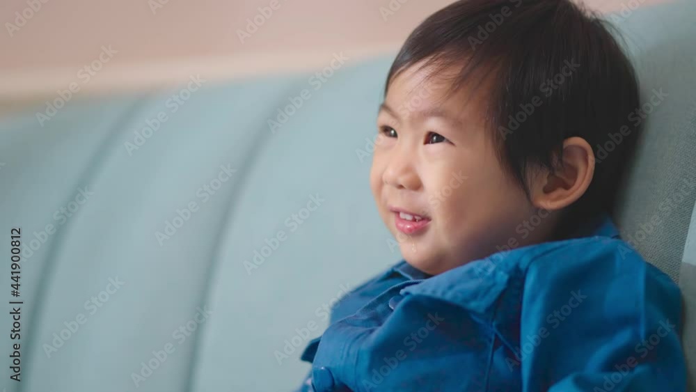 happiness asian baby boy casual cloth smiling and relax enjoy himself on blue sofa couch in living room at home happiness asian baby boy casual cloth smiling and relax enjoy himself on blue sofa couch in living room at home