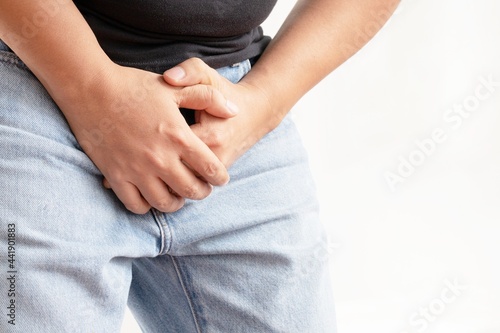 Close-up of a young man holding his penis cause pain prostate cancer ejaculation fertility bladder problems
