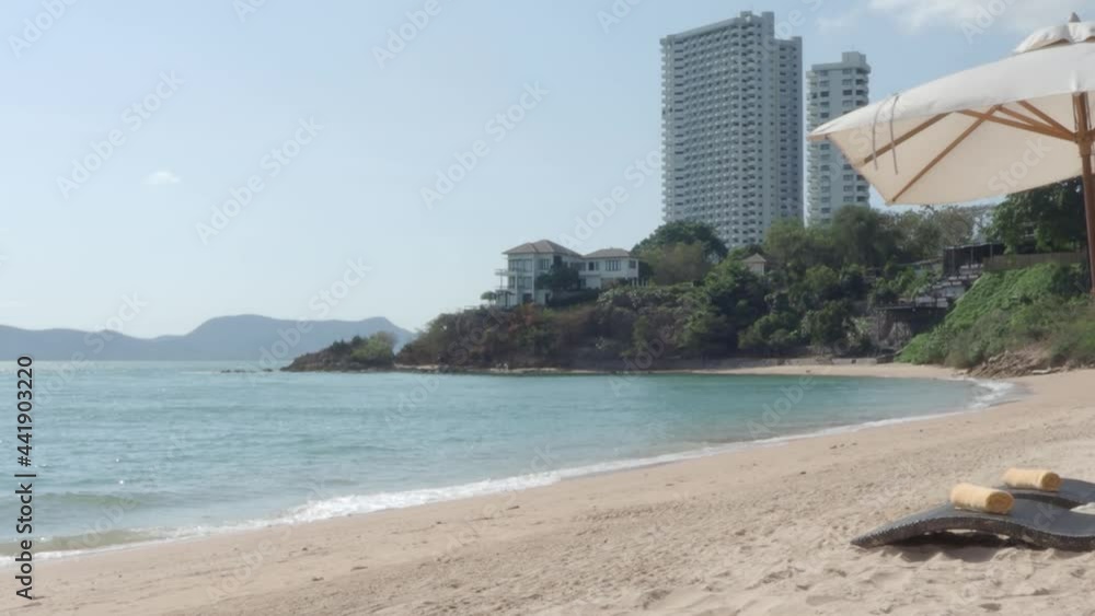 Pattaya Beach. Resort day beds and coffee table with umbrella on the beach. Sea waving with blue sky summer. light wind on beach of Pattaya Thailand. No People during Covid 19 or Coronavirus pandemic.