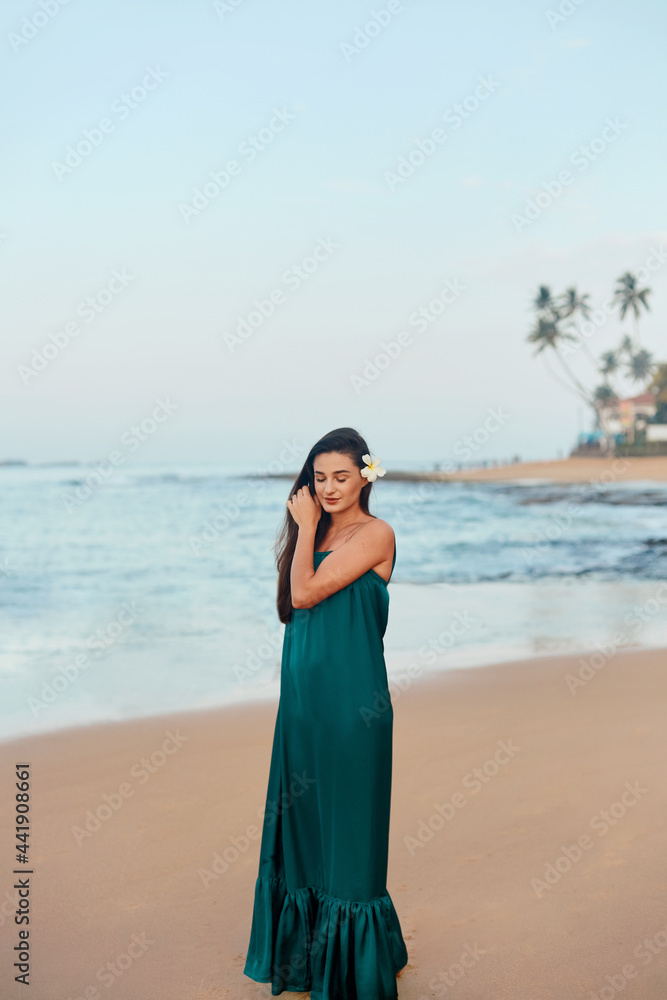 Portrait of beautiful young woman in dress on the beach. Pretty girl on tropical beach. Freedom concept, holiday, beach, sky background. Portrait of beautiful young woman in dress on the beach. Pretty girl on tropical beach. Freedom concept, holiday, beach, sky background.