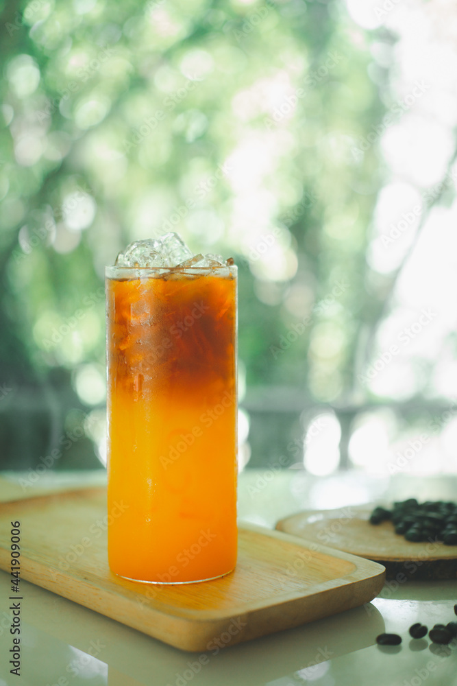 Glass of espresso with orange juice on wooden tray Glass of espresso with orange juice on wooden tray