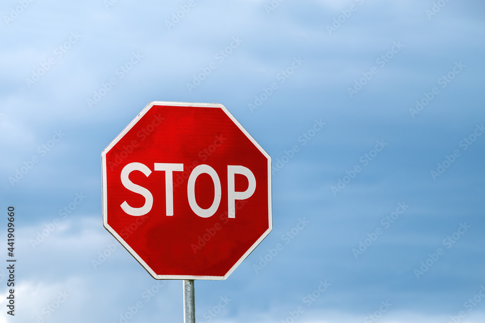 The traffic sign stop on the background clouds and blue sky, free space for texts.