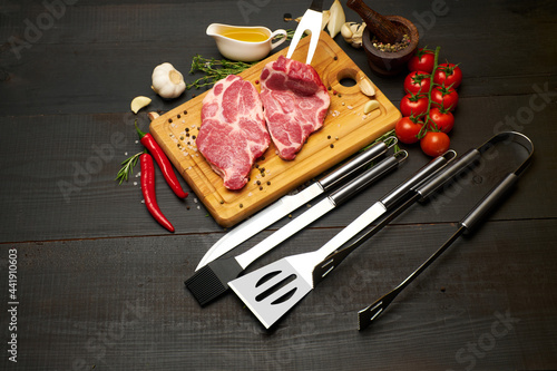 Fresh raw beef or pork steaks on wooden cutting board