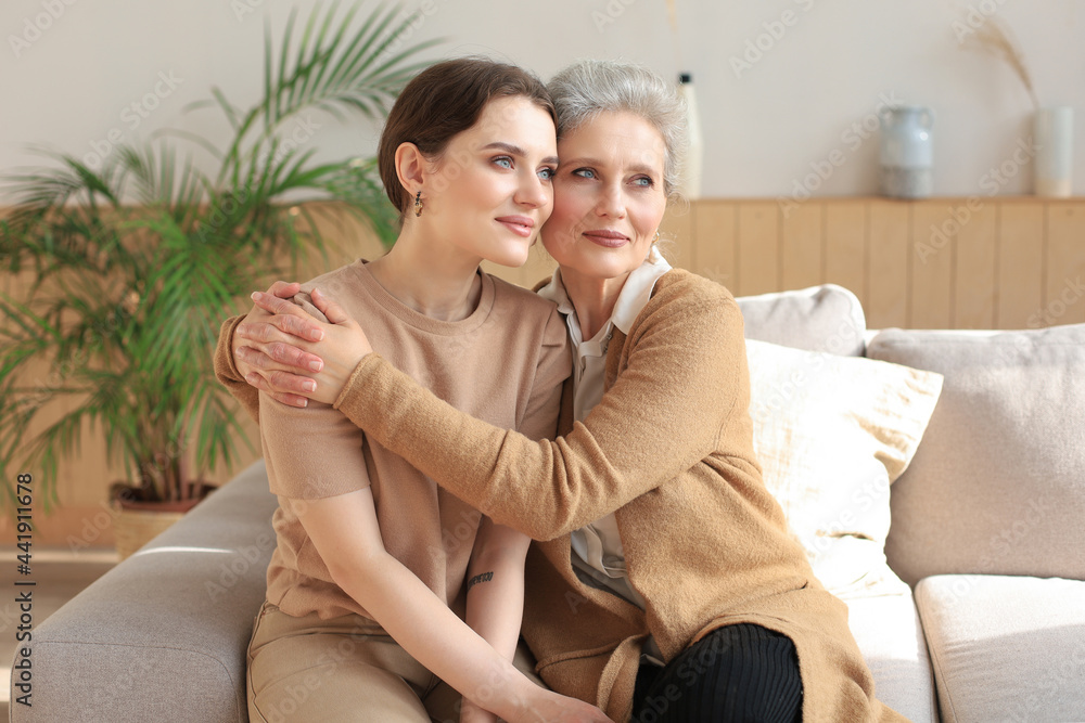 Portrait of old mother and mature daughter hugging at home. Happy senior mom and adult daughter embracing with love on sofa. Portrait of old mother and mature daughter hugging at home. Happy senior mom and adult daughter embracing with love on sofa.