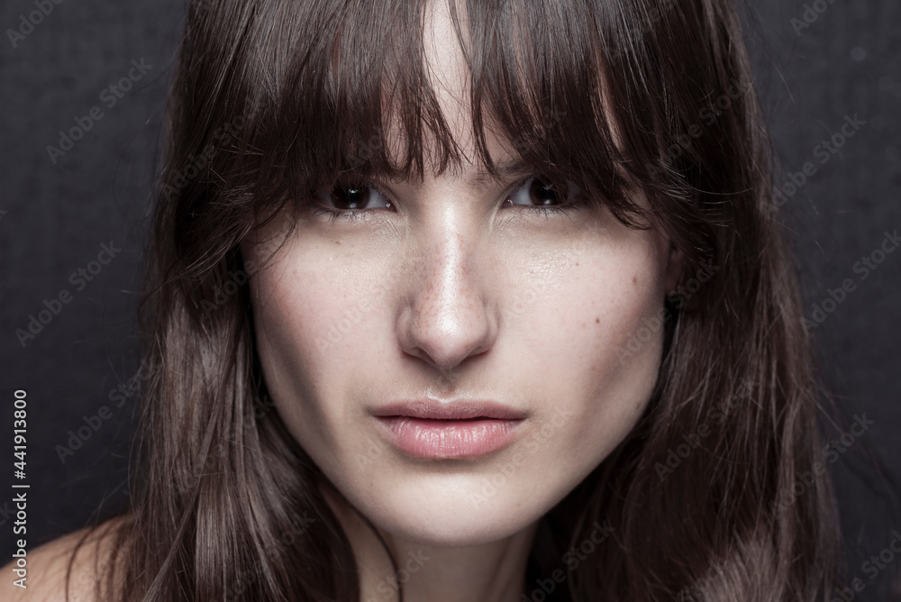 Serious female with makeup and freckles on nose Serious female with makeup and freckles on nose