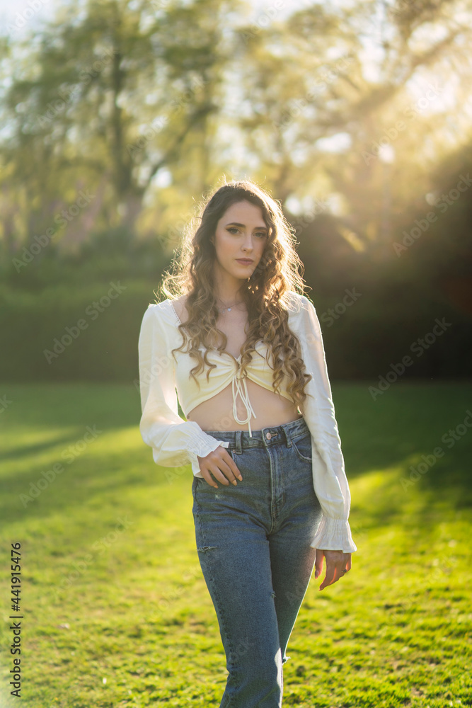 Attractive woman standing in sunny lush park Attractive woman standing in sunny lush park