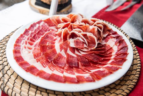 Fotografia Plate of acorn-fed Iberian ham on the table at an event