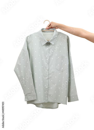 Women hand holding pastel cotton shirt on white background © seksanwangjaisuk