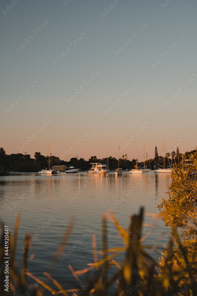 Boats and yachts sitting on the river at sunset on the Clarence River.