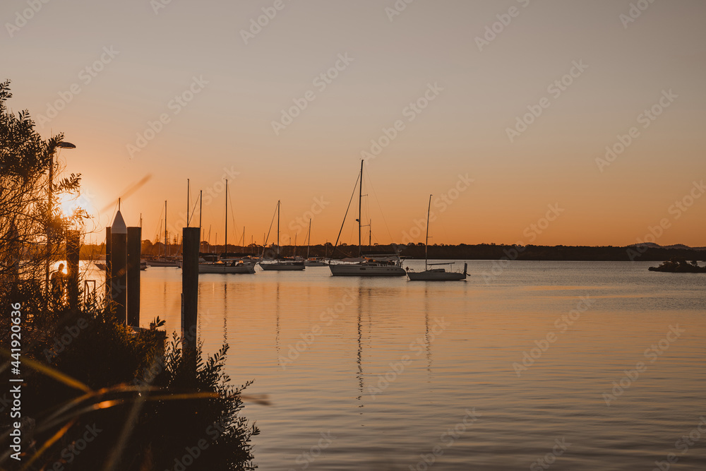 Boats and yachts sitting on the river at sunset near the Yamba Marina on the Clarence River.