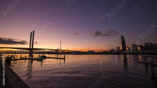 Sunset timelapse video of Bolte Bridge with Melbourne Star Observation Wheel at District Docklands in Melbourne CBD, Australia
