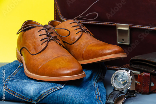 Collection of men's accessories. Men's shoes, jeans, belt, watch, wallet with money and briefcase. Mens accessories background.